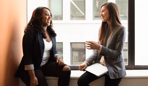 Two lawyers talking while sitting by a window